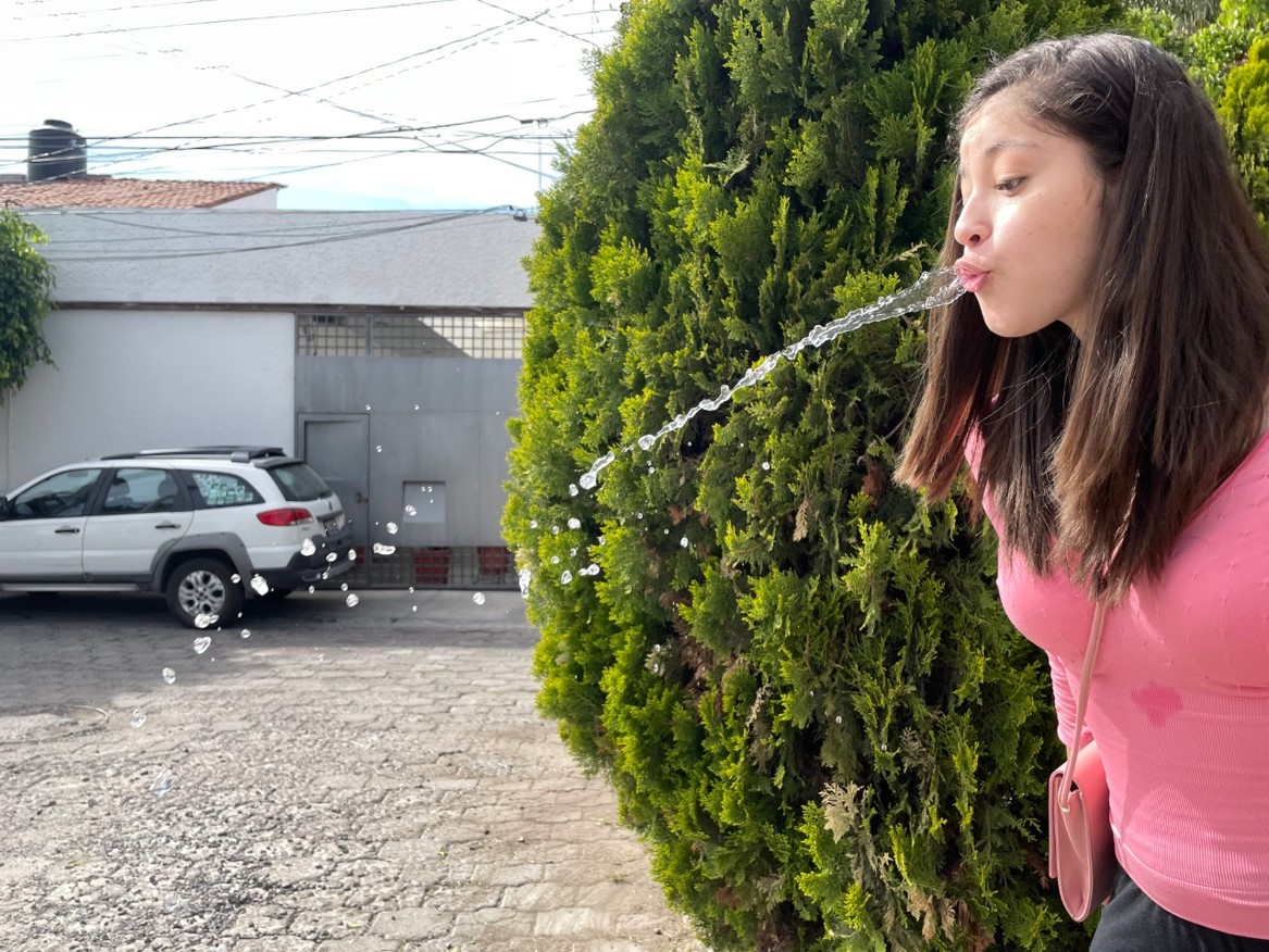 niña escupe chorrito de agua